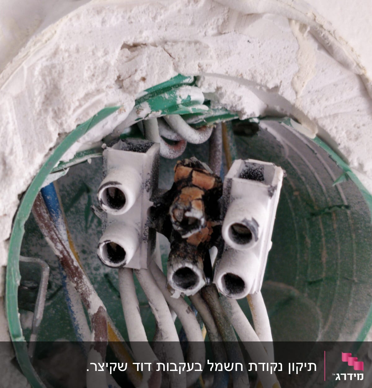 חוטי חשמל מחוברים לקופסת חיבורים בקיר